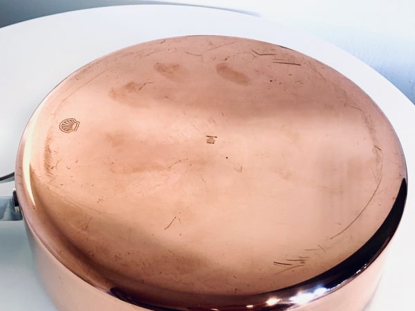 Afbeelding van een koperen sauteerpan van Georg Jensen ontworpen door Henning Koppel die in deze advertentie wordt aangeboden.