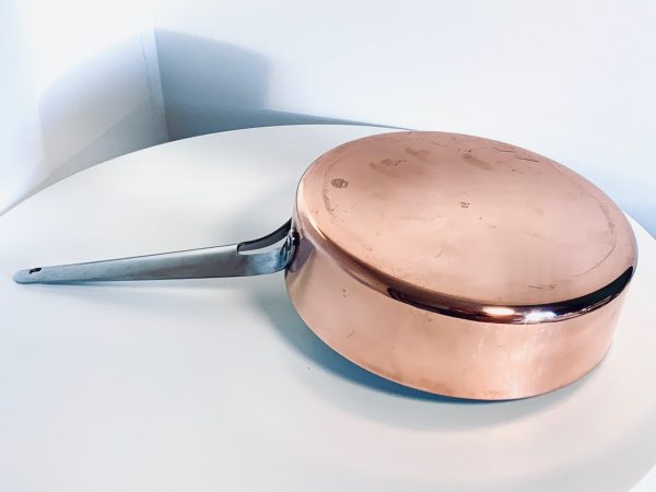 Afbeelding van een koperen sauteerpan van Georg Jensen ontworpen door Henning Koppel die in deze advertentie wordt aangeboden.