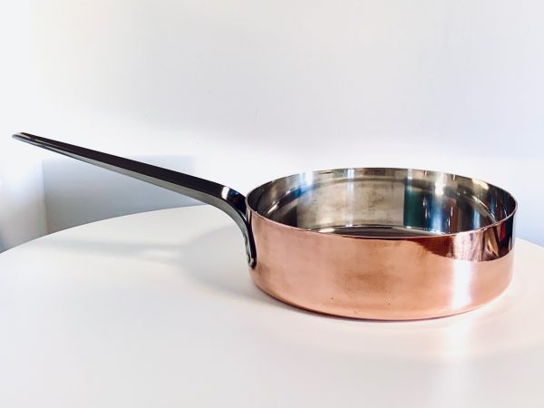 Image d'une sauteuse en cuivre Georg Jensen conçue par Henning Koppel proposée dans cette publicité.